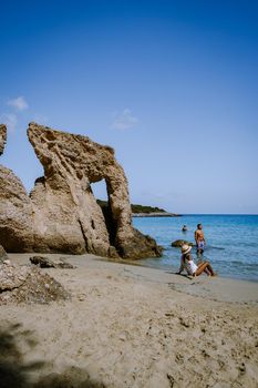 Tropical beach of Voulisma beach, Istron, Crete, Greece Europe, couple men and woman mid age on the beach during vacation in the summer of Europe