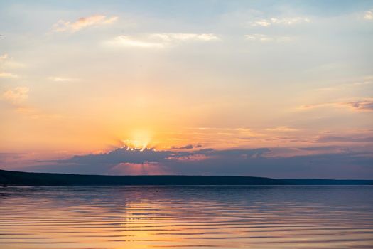 Dramatic sunset over sea water with cloudy sky Golden colored nature background with calm water