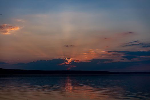 Dramatic sunset over sea water with cloudy sky Golden colored nature background with calm water