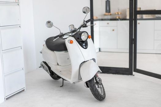 White retro moped standing indoor Vintage scooter stands indoors as interior decoration Nobody