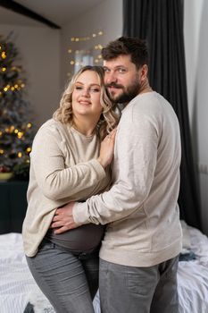 Happy family concept. Husband hug belly pregnant wife standing indoor living room near sofa Caucasian man and woman pregnancy and new life concept. Love and care