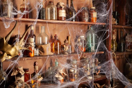 Halloween background Shelves with alchemy tools Skull spiderweb bottle with poison candles Witcher workspace Scarry room