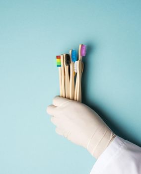 multicolored wooden toothbrushes on a blue background, plastic rejection concept, zero waste