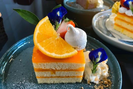 Orange cake with orange topping on plate ready to eat