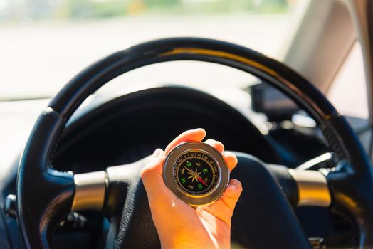 Asian woman inside a car and using compass to navigate while driving the car she find navigation location to go, Transportation and vehicle concept
