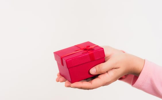 Valentine's Day. Woman beauty hands holding small gift package box present wrapped paper with ribbon isolated on white background, Birthday, New year, Christmas, holiday background concept