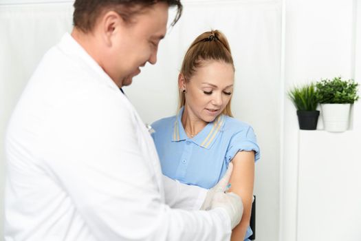 a man in a white coat puts a band-aid on his hand hospital care. High quality photo