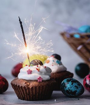 Easter holiday concept. Easter cupcake with a sparkler decorated with colored quail eggs
