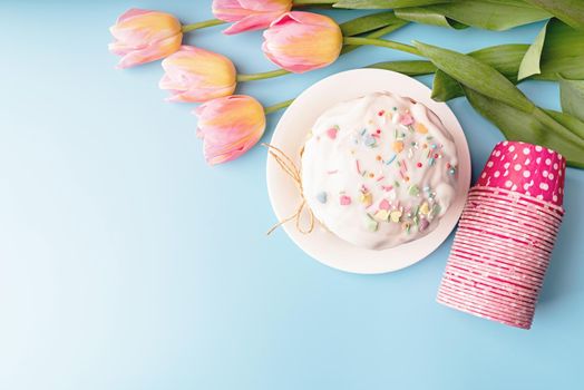 Easter concept. Easter cake with tulips on blue background top view flat lay with copy space