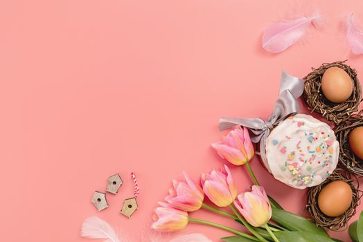 Easter concept. Easter cake with tulips and eggs on pink background top view flat lay with copy space