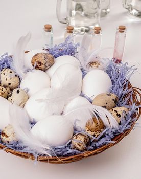 Easter holiday concept. big basket with quail and chicken eggs ready for coloring