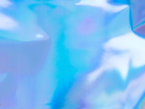 Beautiful holographic rainbow abstract background in pastel and neon color design. Real photography shot of holographic foil for creative project - design fashion, cover, book, printing. Copy space