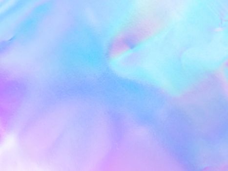 Beautiful holographic rainbow abstract background in pastel and neon color design. Real photography shot of holographic foil for creative project - design fashion, cover, book, printing. Copy space