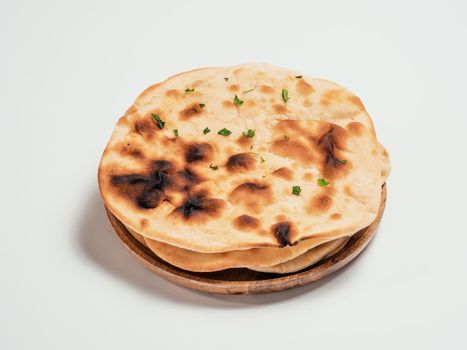 Fresh naan bread on plate isolated on white background. Stack of several perfect naan flatbreads on white.
