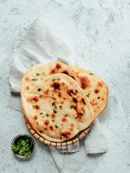 Fresh naan bread on gray cement background with copy space. Top view of several perfect naan flatbreads. Vertical