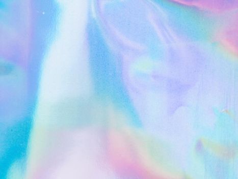 Beautiful holographic rainbow abstract background in pastel and neon color design. Real photography shot of holographic foil for creative project - design fashion, cover, book, printing. Copy space
