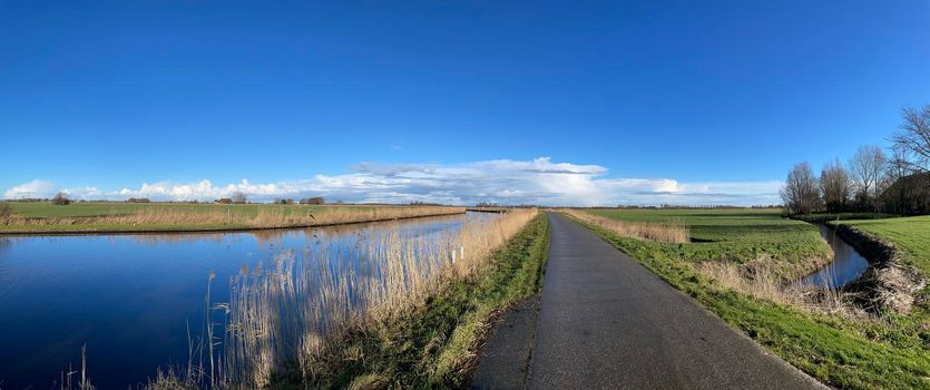 Panorama from road next to a canal on a winter day around Akkrum in Friesland The Netherlands