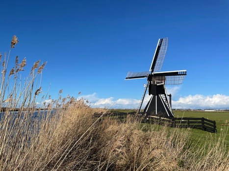 Windmill next to a canal around Akkrum in Friesland The Netherlands