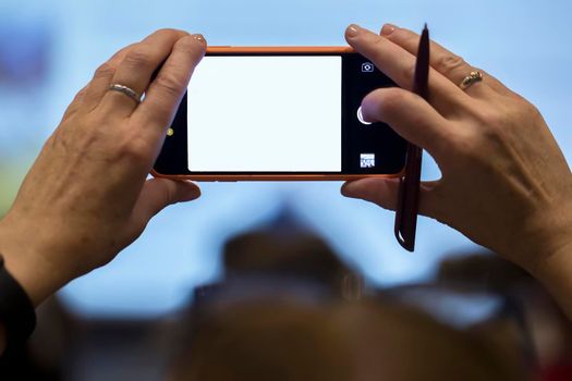 26.09. 2019 Belarus, the city of Minsk. Meeting and conference of bank employees.Hands hold a phone with a blank screen. Glowing blank smartphone screen.
