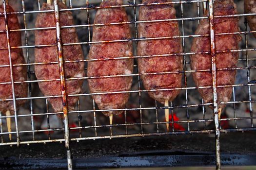 Meat dish on the wire rack. Lula kebab oriental sausages.