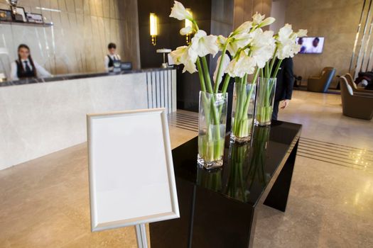 The lobby of the hotel is decorated with vases with flowers.