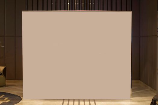 A blank white advertising banner stands in the lobby of the room.