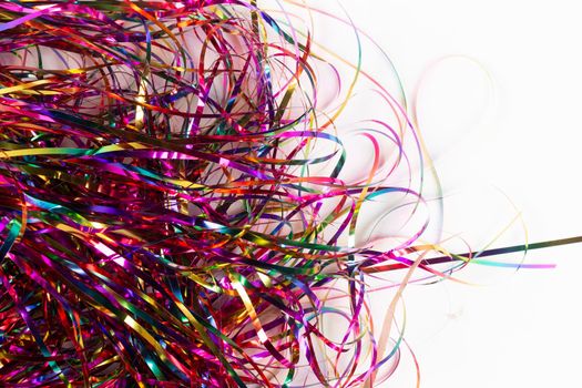 Festive background. Lots of multicolored tinsel close-up on a white background.