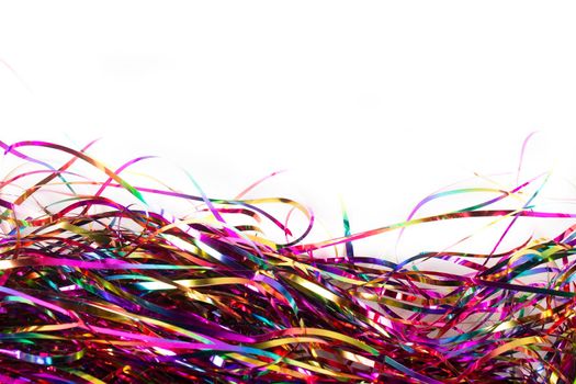 Festive background. Lots of multicolored tinsel close-up on a white background.