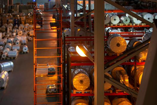 Industrial warehouse with metal shelves and paper rolls. Pulp industry.