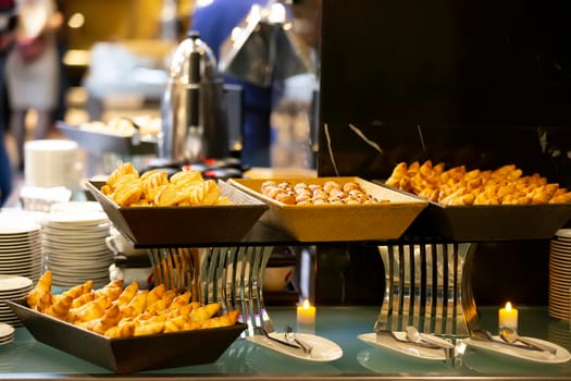 Cookies or small cakes in a bowl at a buffet table.