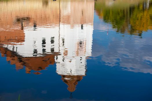 Reflection of an old castle in blue water.