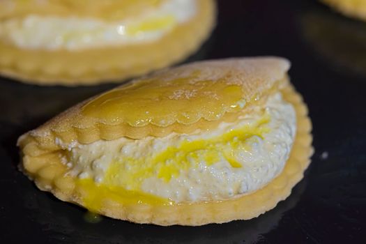 Cookies with cottage cheese on a baking sheet smeared with egg yolk.