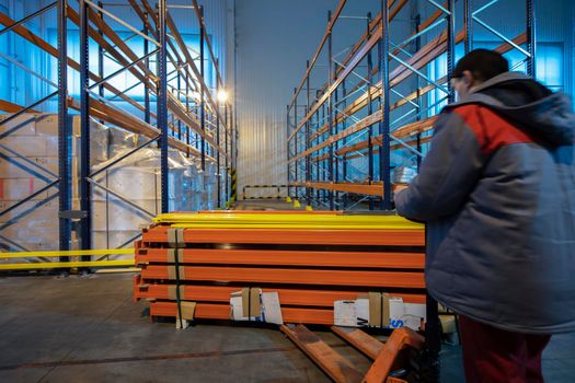 Warehouse premises of a factory or workshop with metal shelves.