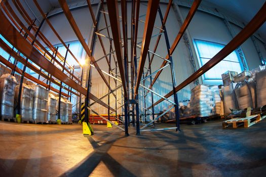 Warehouse premises of a factory or workshop with metal shelves.