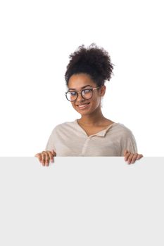 Portrait casual black woman in glasses displaying a banner ad isolated over a white background