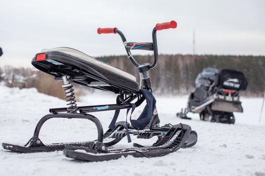 The children's snowmobile is ready for children to ride. Entertainment activities for children riding in the snow in winter