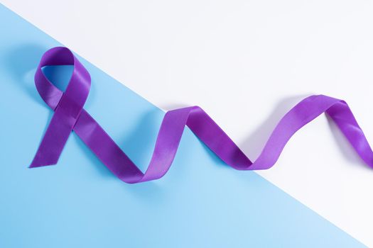 World cancer day, purple ribbon on with and blue background with copy space for text. Healthcare and medical concept.