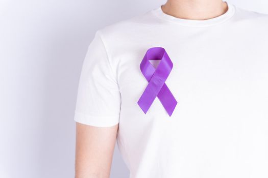 World cancer day, purple ribbon on chest isolated grey background. Healthcare and medical concept.