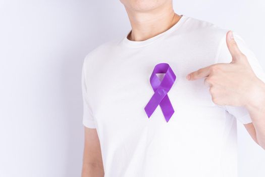 World cancer day, purple ribbon on chest isolated grey background. Healthcare and medical concept.