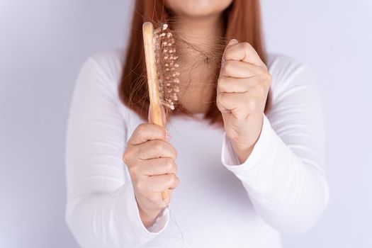 Hair fall problem, closeup hand holding comb and problem hair. Healthcare medical or daily life concept.