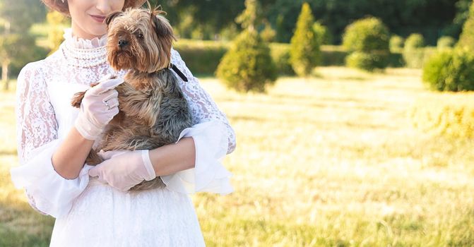 Retro portrait of a beautiful woman holding Yorkshire terrier