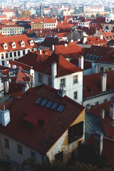 Top view to red roofs skyline of Prague city, Czech republic. Beautiful panoramic view of an famous historical city, during a vibrant winter sunrise.