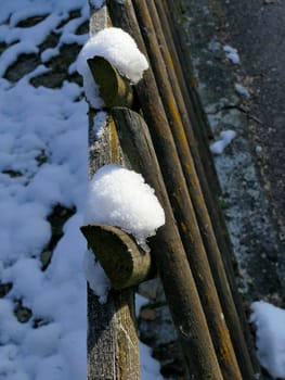 snow hats on a wooden fence
