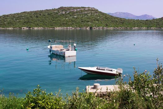 Two small fishing boats in calm waters of Mediterranean Adriatic sea in Croatia