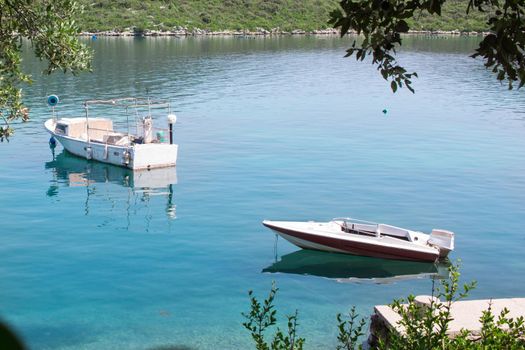 Two small boats in calm waters of Mediterranean Adriatic sea in Croatia