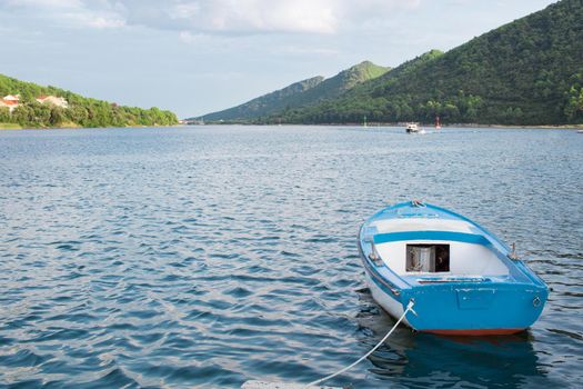 Small fishing boat in Mediterranean sea bay of Adriatic Croatia tied to shore