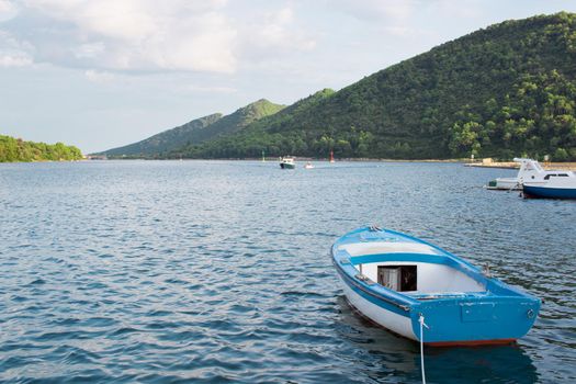 Small fishing boat in Mediterranean sea bay of Adriatic Croatia tied to shore