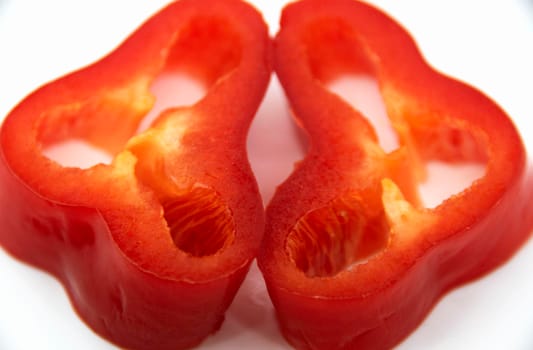 Capi of ripe juicy sweet pepper cut into rings on a white plate.