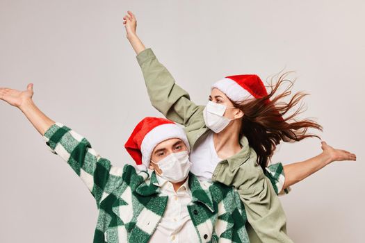 Christmas mood man and woman fun holiday hat medical mask. High quality photo