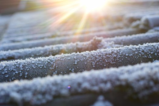 Sunrise over a frozen roof with moss and ice